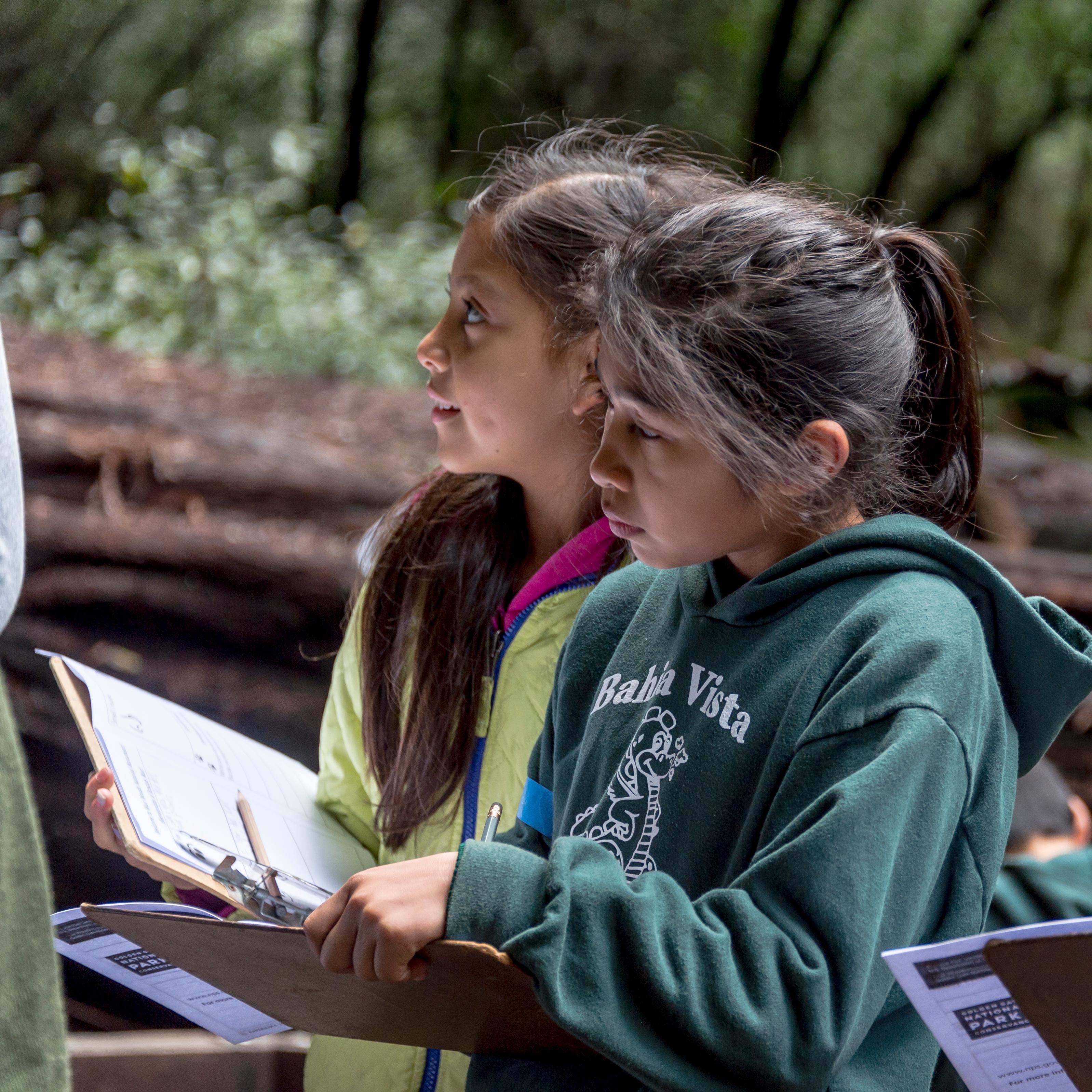 Students stand at Muir Woods with journals in their hands