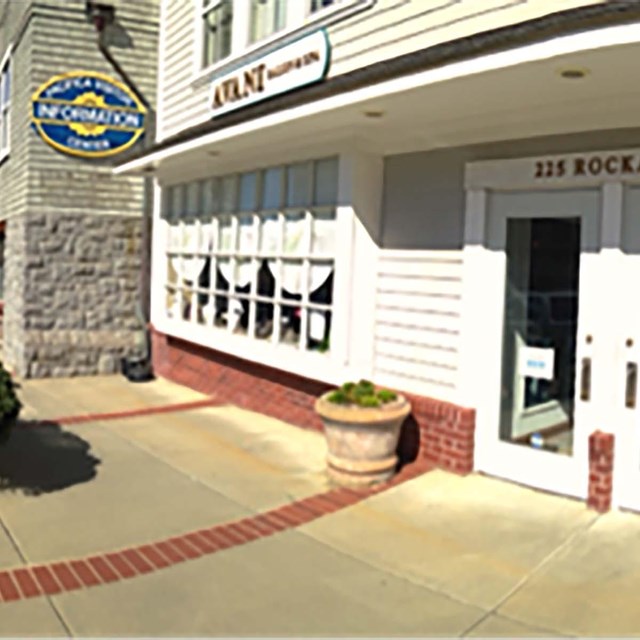 front of door of visitor center with 225 Rockaway on the frame