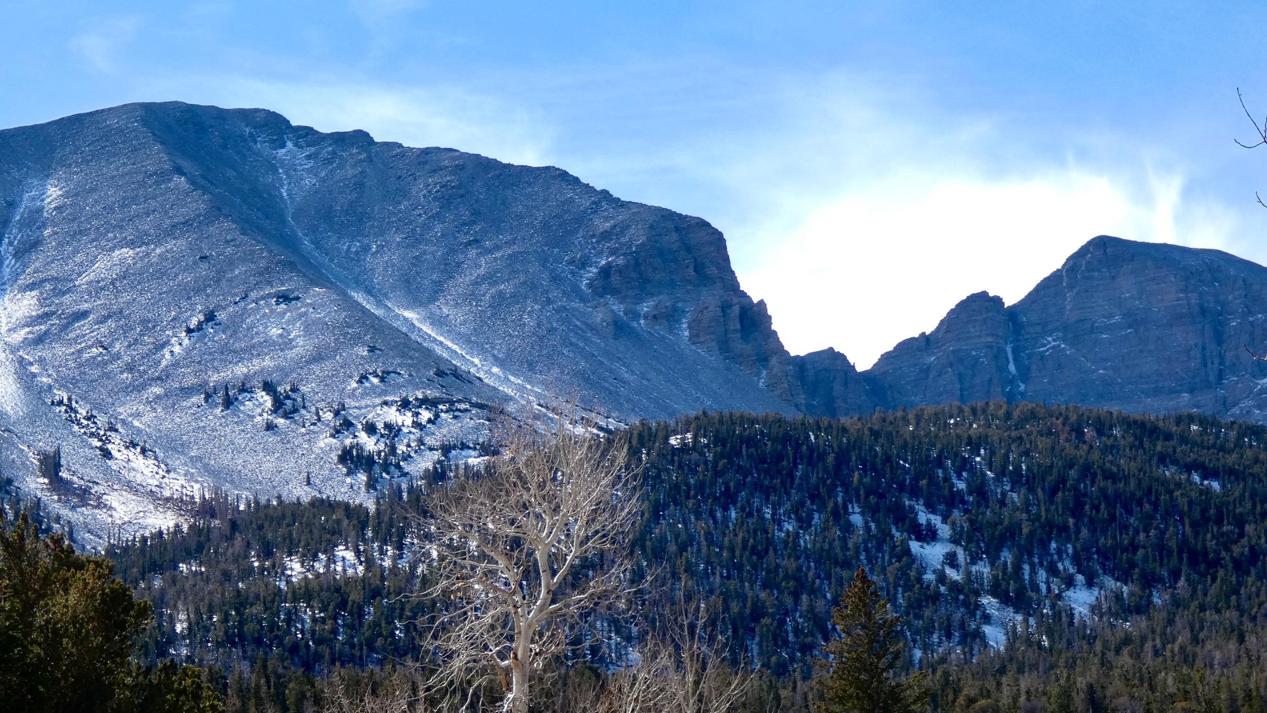 Distant mountain peaks with a mix of clouds and blue sky in the background.