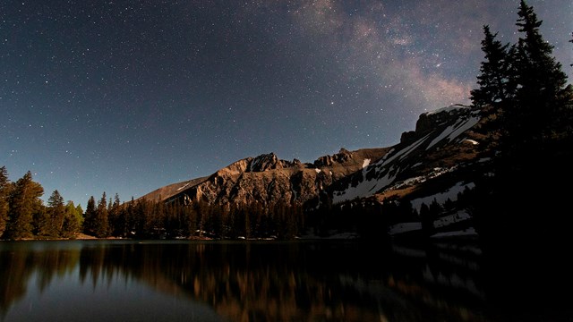 Mountain Lake and Wheeler peak illuminated at night by the moon.