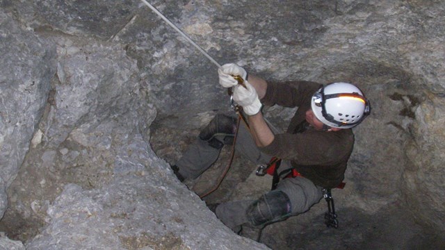 Person using single rope technique to exit a wild cave