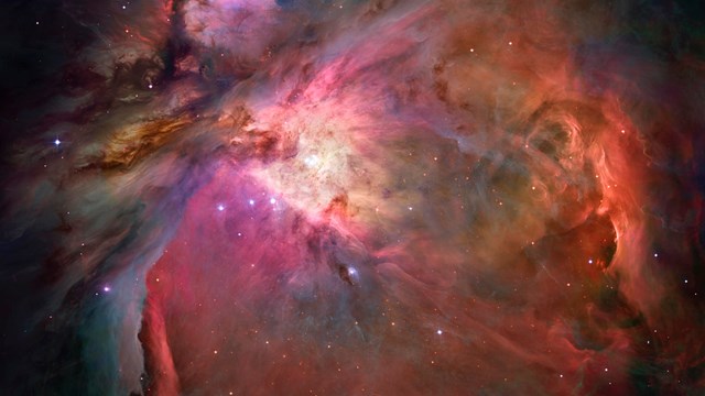 The swirling pink, orange and yellow dust of the Orion Nebula.