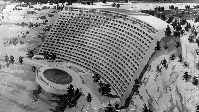 A black and white photo of a hotel on the rim of the canyon.