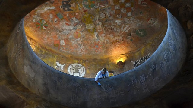 A conservator conducts mural conservation work in the Desert View Watchtower.