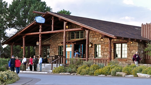 A group of people standing outside the entrance of a hotel