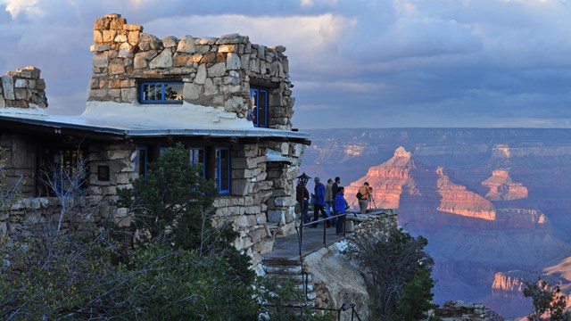 A stone building with the Grand Canyon in the background.