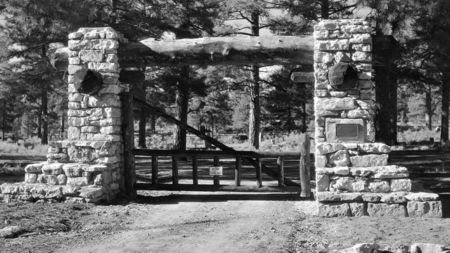 A black and white photo of the gate of the Pioneer Cemetery.