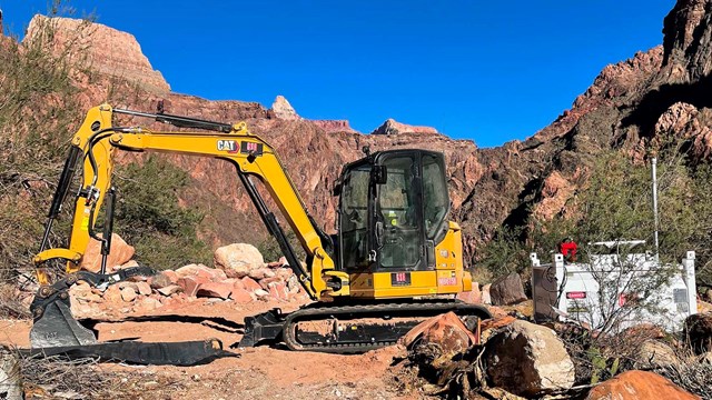a front-loader tractor clearing an open area deep within the walls of Grand Canyon.