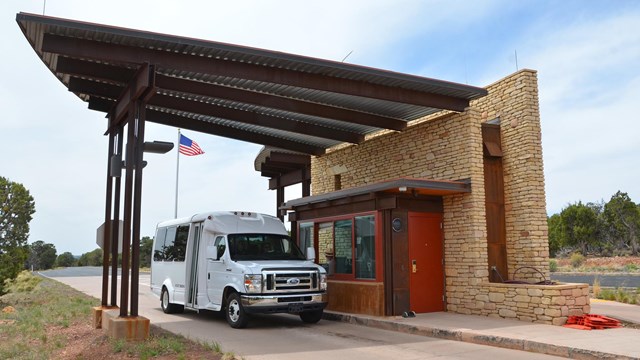 A white car at a stone entrance station