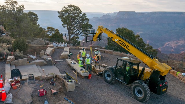 Construction workers position a large slab of stone for the Desert View amphitheater. 