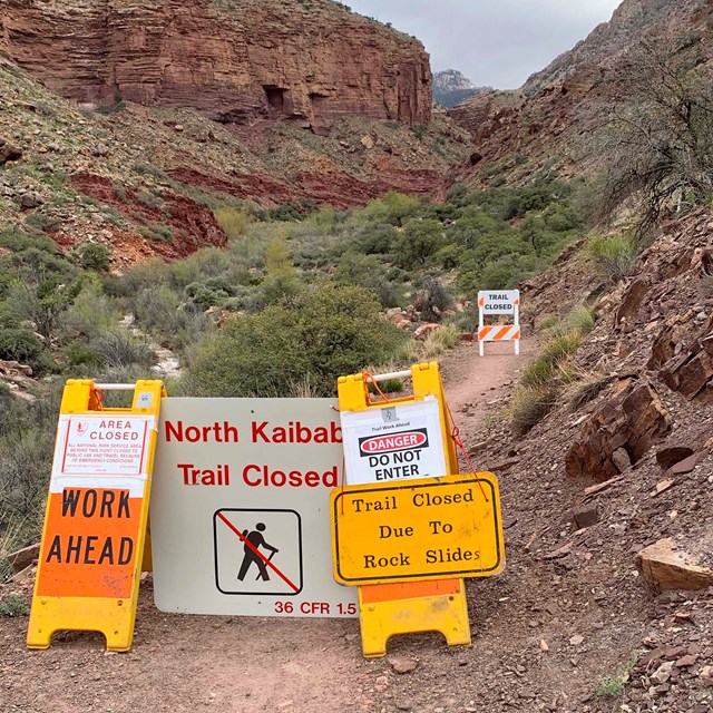 Closure sign reads, 'WORK AHEAD'. North Kaibab Trail Closed Due To Rock Slides. Danger, do not enter