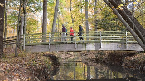 Hikers walking across a bridge on the Perimeter Trail