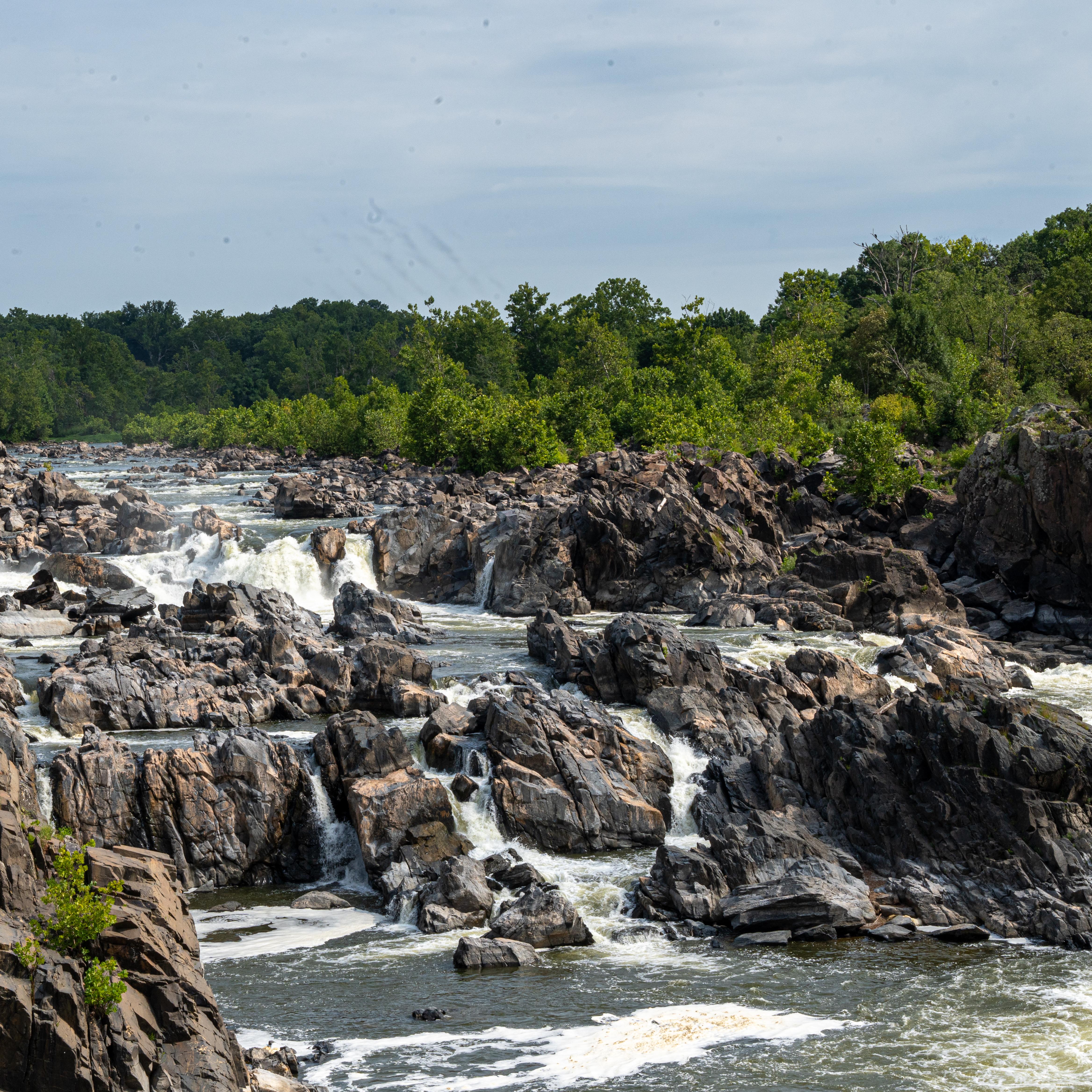 Water cascades down dark grey granite rock.