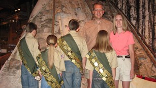 Junior rangers wearing sashes festooned with Junior Ranger badges