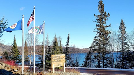 The Heritage Center sign and flagpoles with a view of the bay.