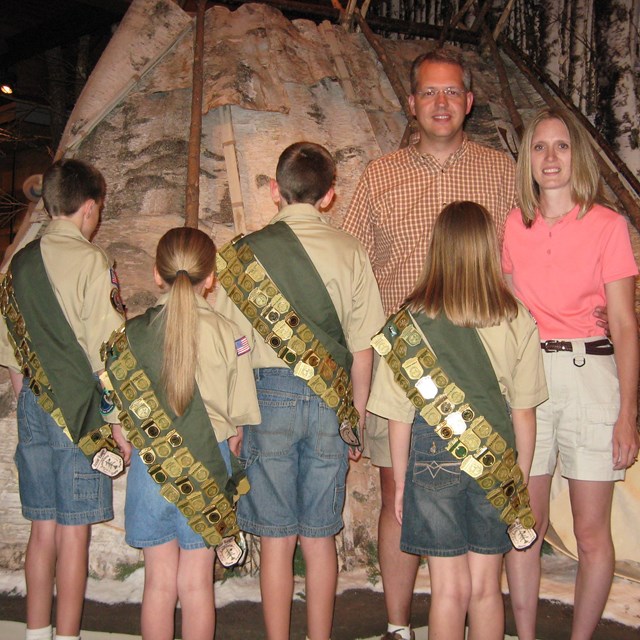Junior rangers wearing sashes festooned with Junior Ranger badges