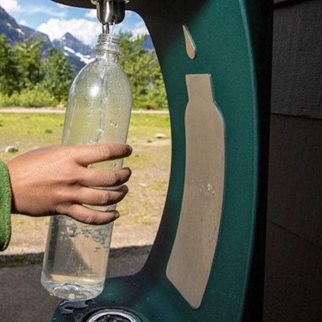 A bottle being filled at a water station.