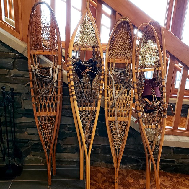 Historic wood frame snowshoes leaning against a bannister.