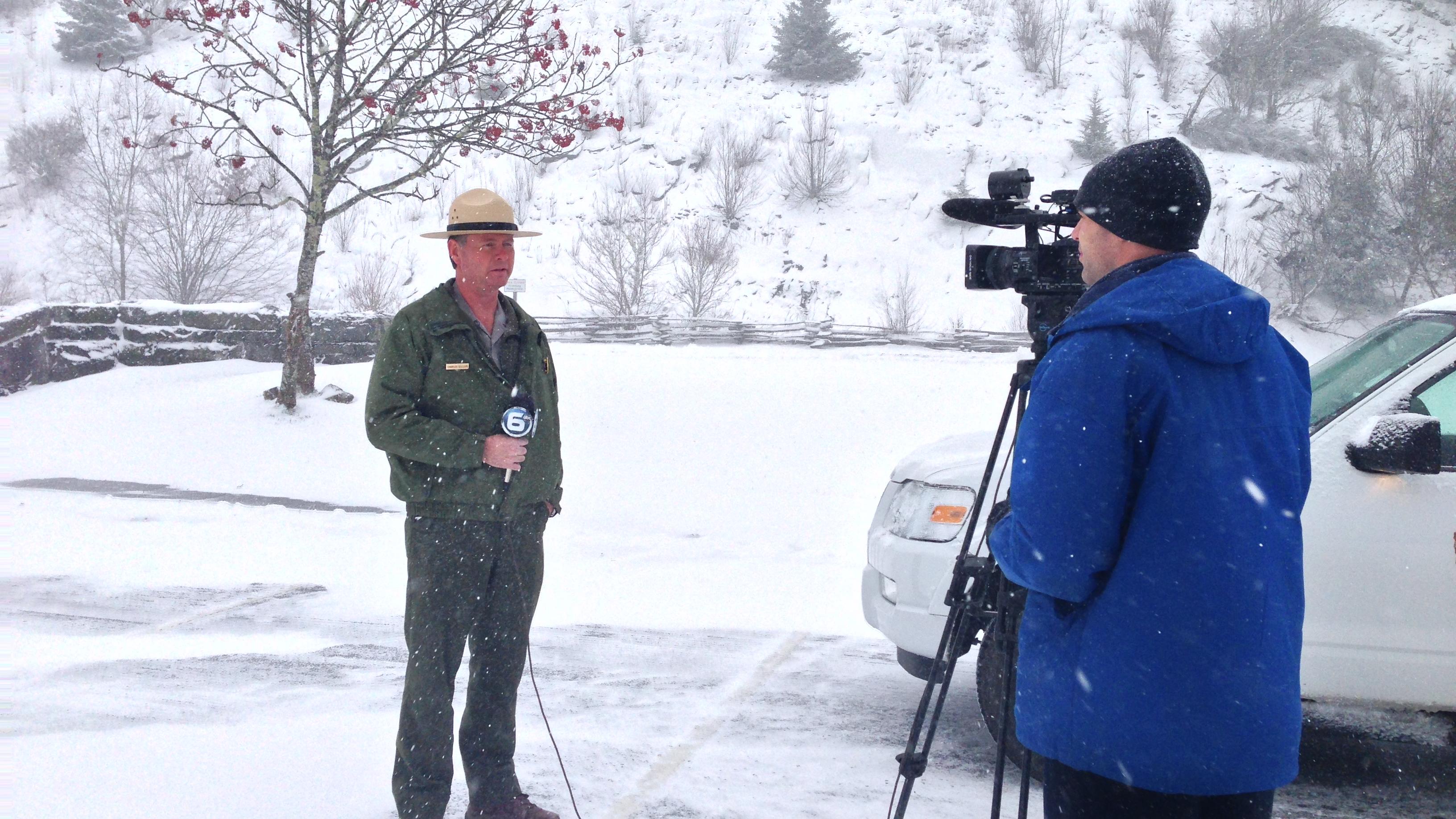 A person getting filmed by media in the snow.