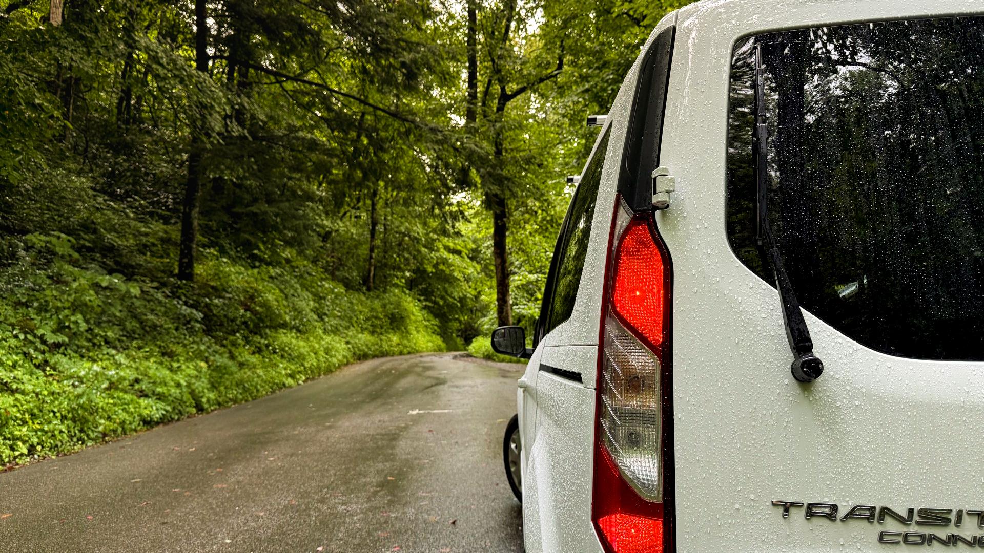A transit van parked on the side of a road.