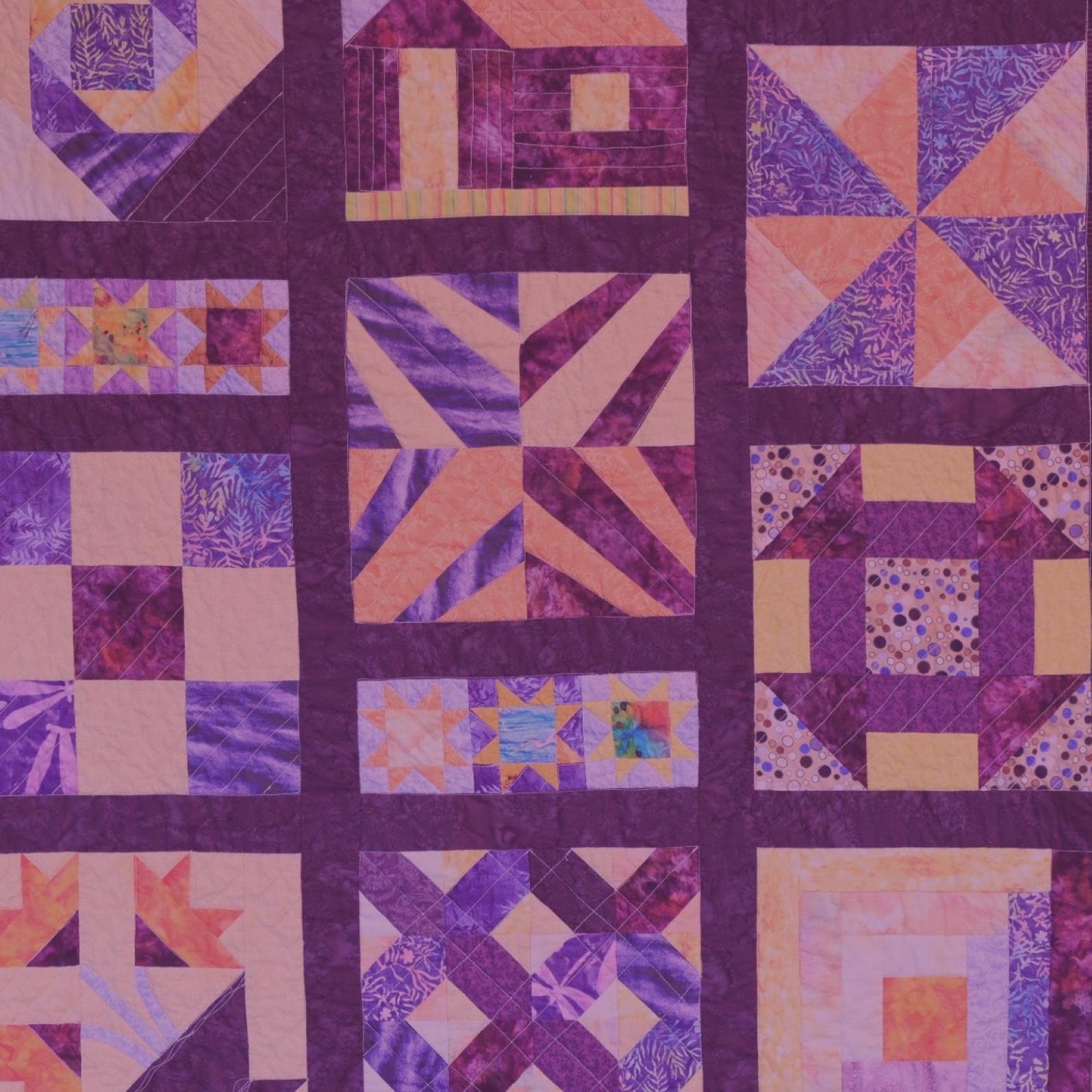 A quilt that is patterned and purple and yellow