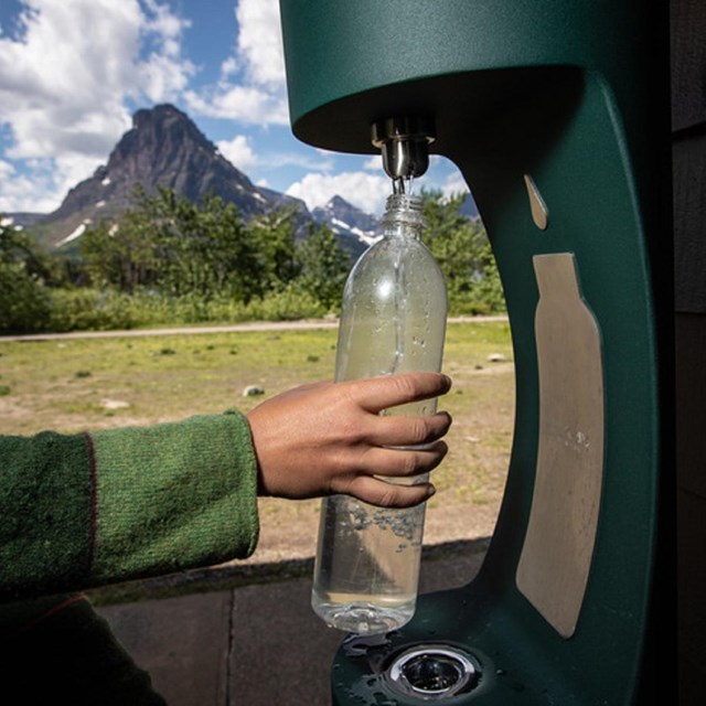 A water bottle filling station is used to refill a water bottle.