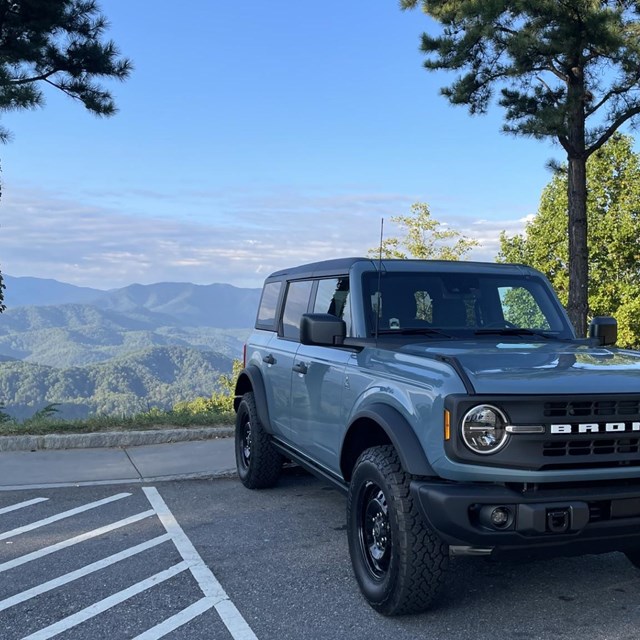 A blue bronco parked at a scenic pull-out.