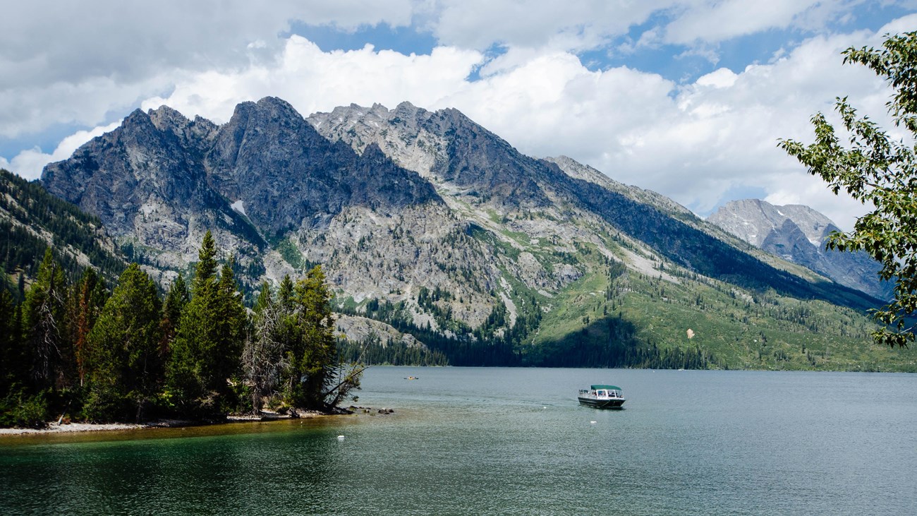 A boat on a lake with mountains in the background.