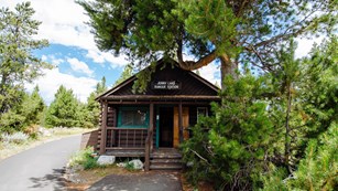 A wood cabin with a sign reading "Jenny Lake Ranger Station".