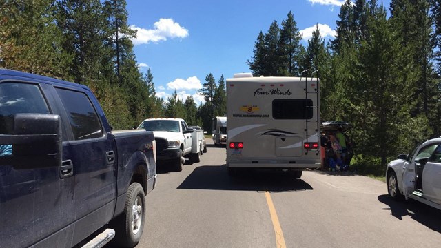 Congested road with vehicles parked on both sides