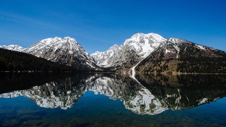 Mountains reflected on a calm lake.