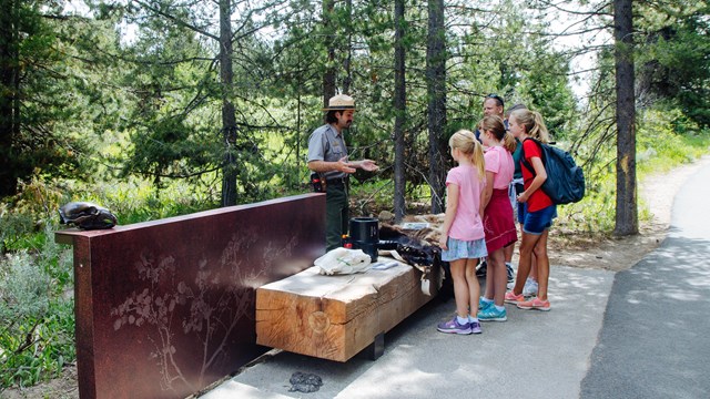 a park rangers talks to a family outside