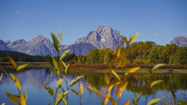 mountains rise above a calm body of water