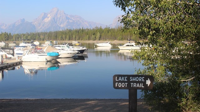 Boats in a marina with mountains in the background.
