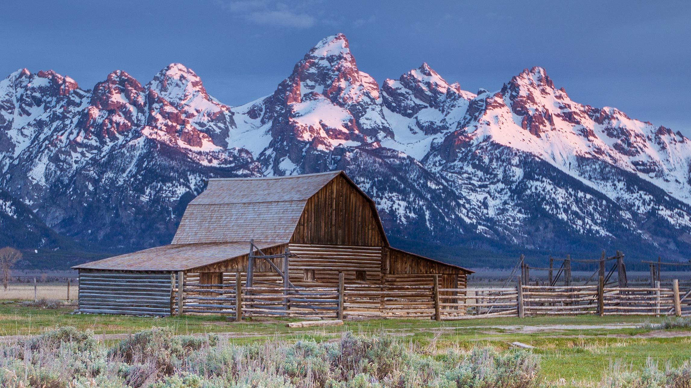 TA Moulton historic barn in the morning mist Teton Range beyond.