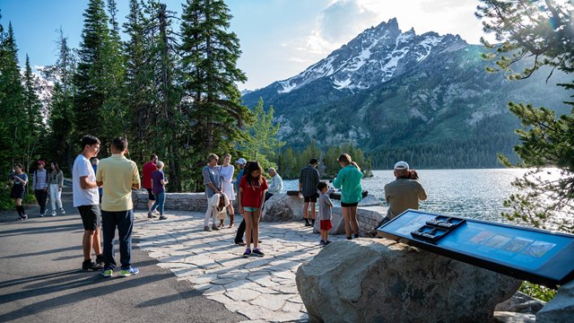 Visitors enjoying an overlook at South Jenny Lake with Mount Teewinot in the background