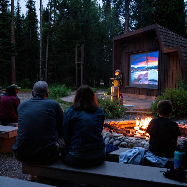 A ranger talks to kids outside.