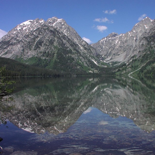 Tall mountains reflected in a large lake.