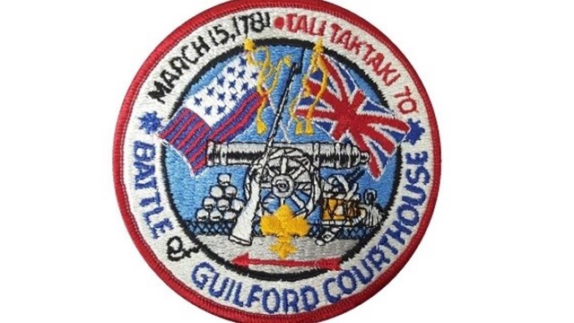 A Boy Scout patch featuring guns, cannon balls, American Revolution flags and Boy Scout text