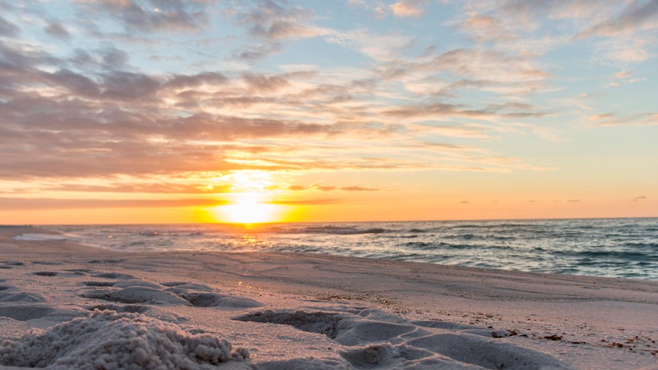 Blue-green waves crash against the white sand beaches of Gulf Islands National Seashore.