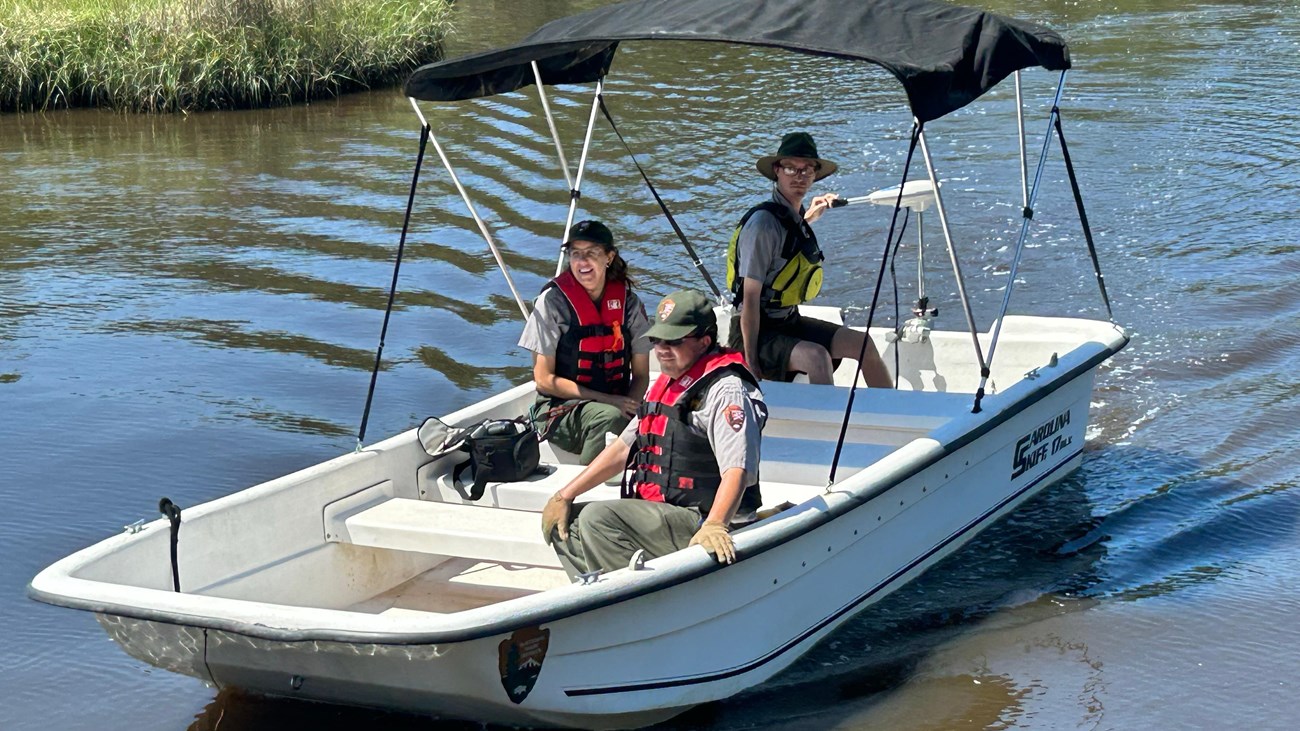 Three people on a boat.