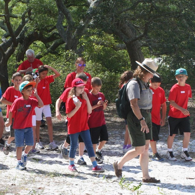 Children grouped around a park ranger.