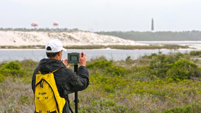 Scientist for the Gulf Coast Network records dune elevation 