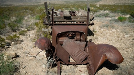 Remains of a vintage automobile in a desert landscape
