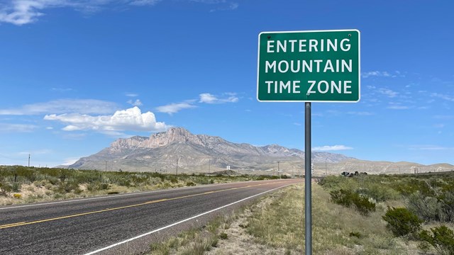 Mountain Time Zone Sign is visible with the mountains in the background