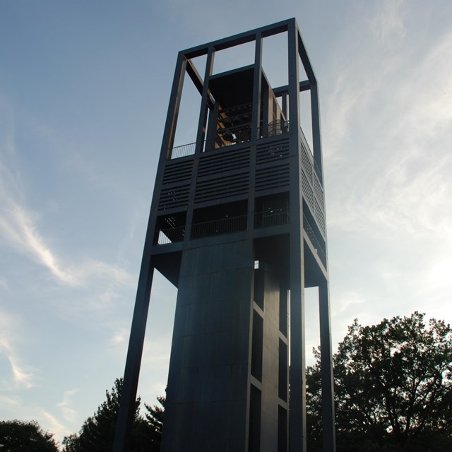 A tall rectangular metal structure with bells in it.