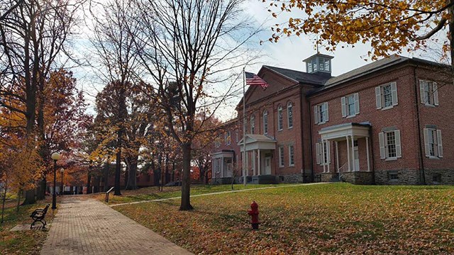 a large brick building with a brick walkway out front