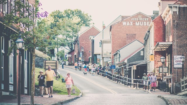 looking up High Street, showing people walking from shops and restaurants outside of the park