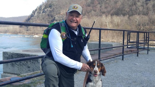 man in volunteer uniform, posing with his dog