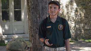 young man in a volunteer uniform talking to a visitor